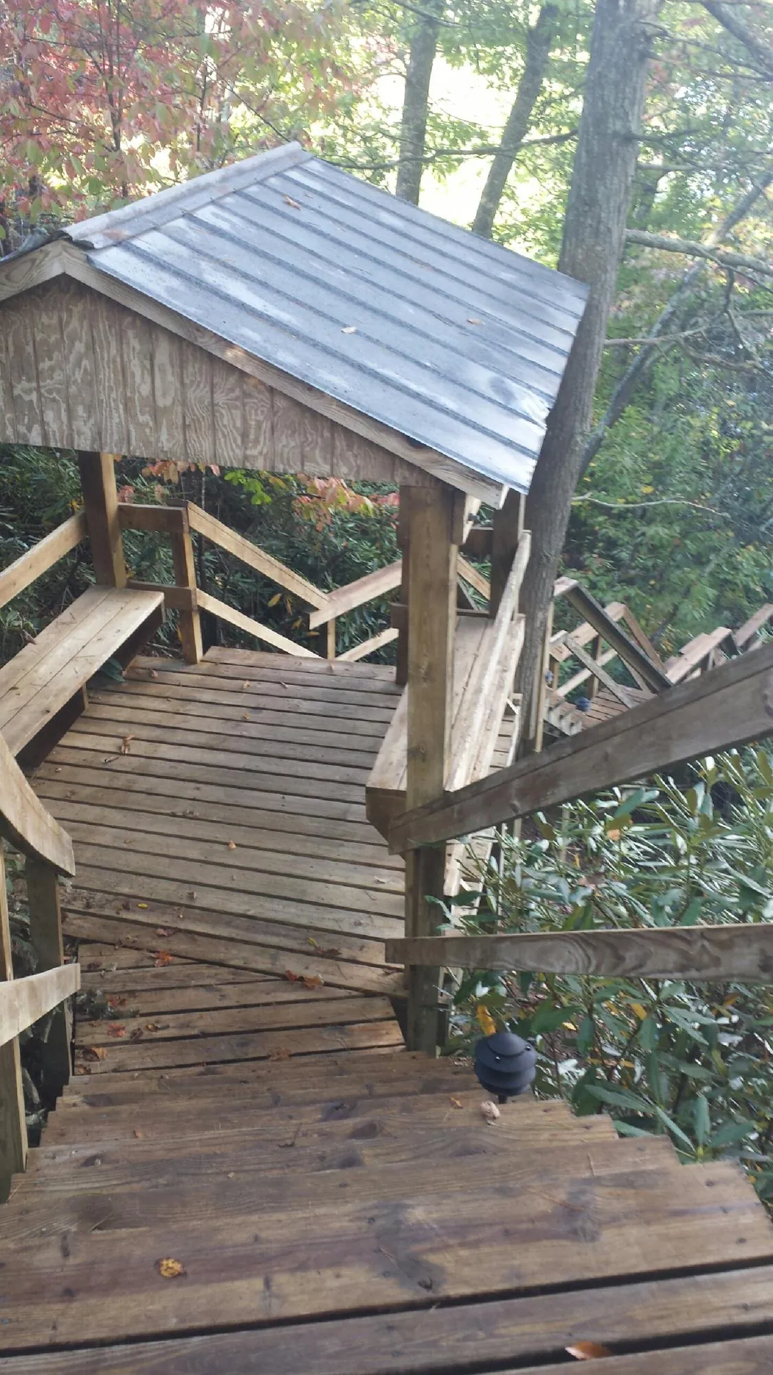 Metal roofed shelter over wooden steps on a wooded walkway — Skylight Repair & Installation work by our crew in Stockbridge